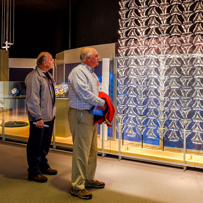 two guests admiring a big glass piece