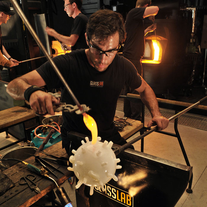 artist blowing a glass 